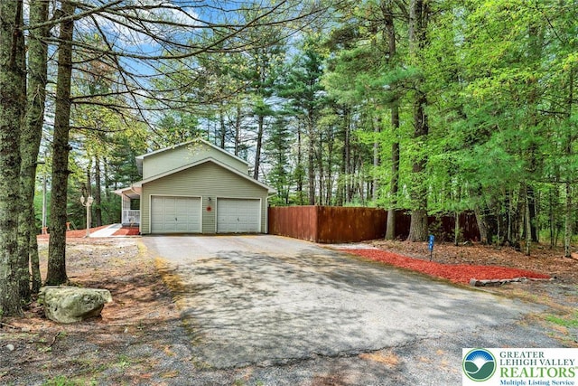 146 Bernadette Dr, Pike, PA 18328 - garage with asphalt driveway and a wooded view