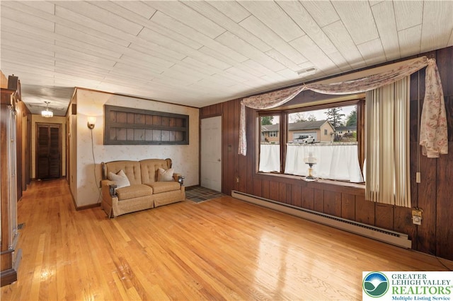 155 7th St, Tatamy Borough, PA 18085 - unfurnished living room featuring a baseboard heating unit, light wood-style flooring, and wooden walls