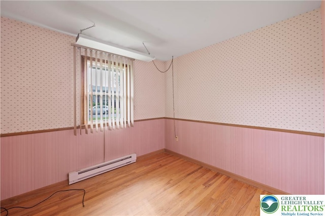155 7th St, Tatamy Borough, PA 18085 - spare room featuring baseboard heating, a wainscoted wall, wood finished floors, and wallpapered walls