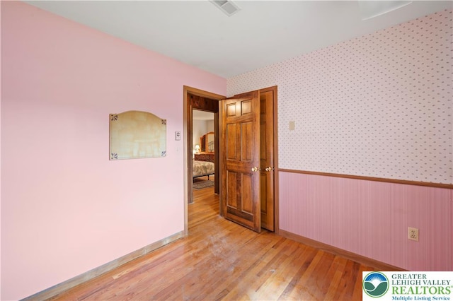 155 7th St, Tatamy Borough, PA 18085 - unfurnished room featuring a wainscoted wall, light wood finished floors, baseboards, and wallpapered walls