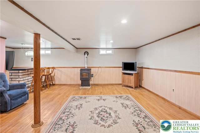 155 7th St, Tatamy Borough, PA 18085 - below grade area with light wood finished floors, a wood stove, wainscoting, and crown molding