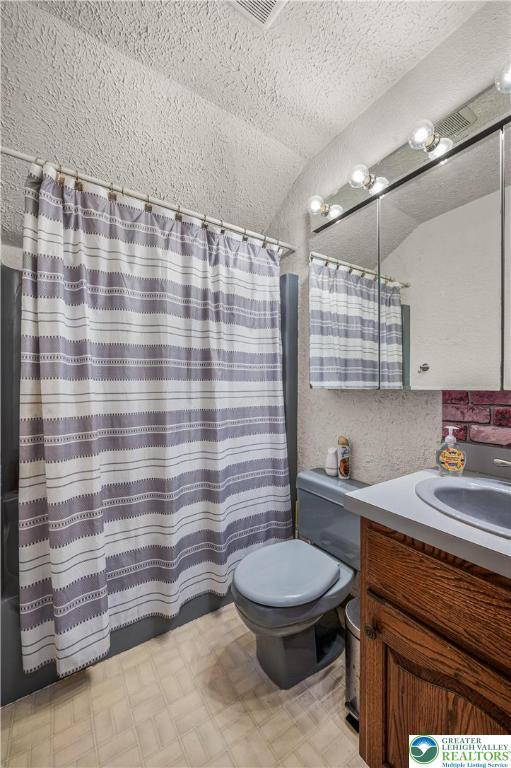 1117 Belaire Dr, Stroud Twp, PA 18301 - full bathroom featuring toilet, vaulted ceiling, vanity, a shower with shower curtain, and tile patterned floors