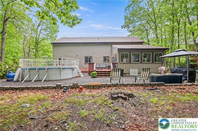 1117 Belaire Dr, Stroud Twp, PA 18301 - back of property with a gazebo, a wooden deck, an outdoor pool, and roof with shingles