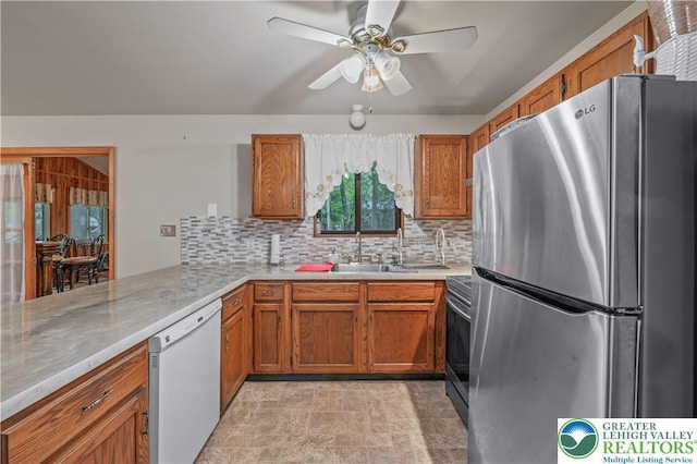 1117 Belaire Dr, Stroud Twp, PA 18301 - kitchen featuring stainless steel appliances, brown cabinets, decorative backsplash, and light countertops