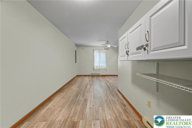 1117 Belaire Dr, Stroud Twp, PA 18301 - empty room featuring light wood-style floors, baseboards, a ceiling fan, baseboard heating, and a baseboard radiator