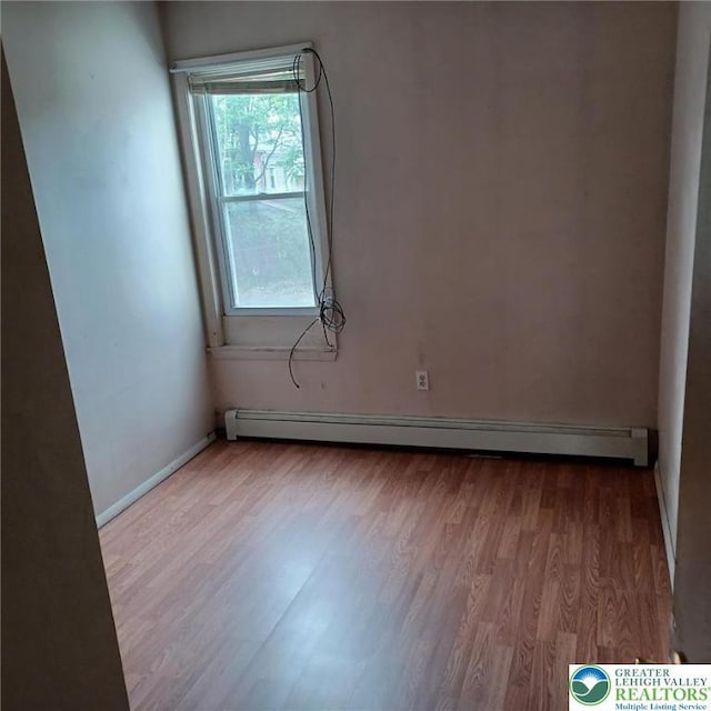 617 Oak St, Allentown City, PA 18102 - spare room featuring a baseboard heating unit, wood finished floors, and baseboards