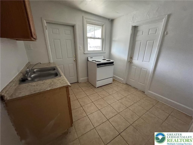 734 W Gordon St, Allentown City, PA 18102 - kitchen featuring white electric stove, light tile patterned floors, a sink, baseboards, and light countertops