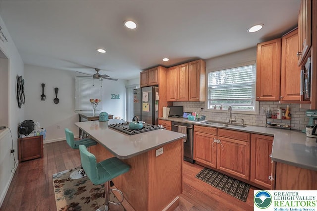 48 Craigie St, Easton, PA 18045 - kitchen featuring a sink, stainless steel appliances, a breakfast bar area, decorative backsplash, and a ceiling fan