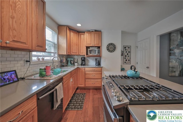 48 Craigie St, Easton, PA 18045 - kitchen with appliances with stainless steel finishes, wood finished floors, a sink, backsplash, and light countertops