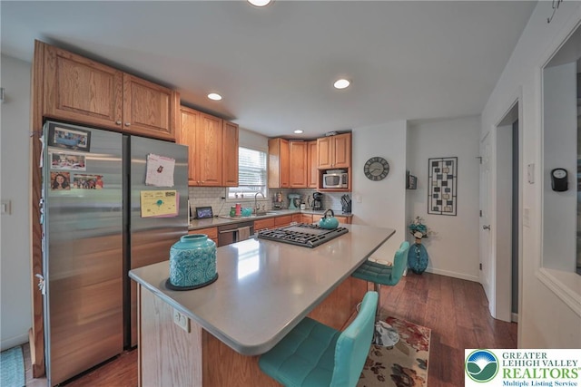 48 Craigie St, Easton, PA 18045 - kitchen with appliances with stainless steel finishes, dark wood-style floors, a center island, tasteful backsplash, and light countertops