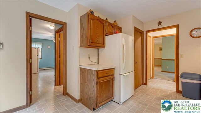 54 Indian Trl, Penn Forest Township, PA 18229 - kitchen with freestanding refrigerator, light countertops, brown cabinetry, a baseboard radiator, and baseboards