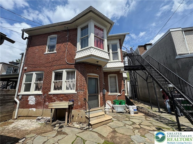 528 N 6th St, Allentown City, PA 18102 - view of front of home featuring entry steps, brick siding, a patio area, and stairway