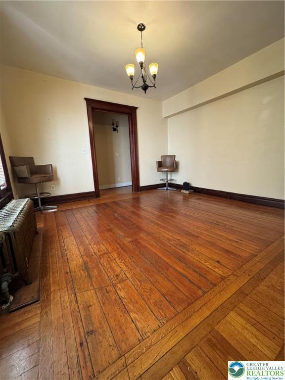 528 N 6th St, Allentown City, PA 18102 - unfurnished living room featuring a chandelier, hardwood / wood-style flooring, and baseboards