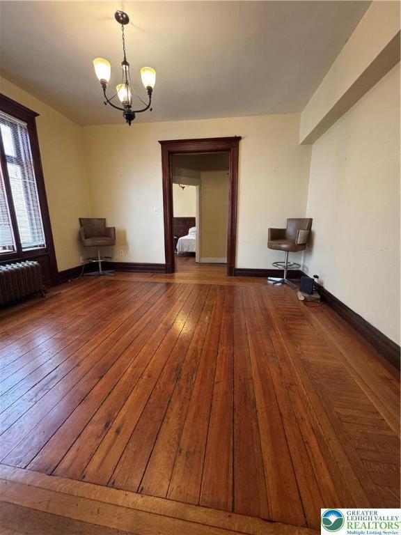 528 N 6th St, Allentown City, PA 18102 - spare room featuring radiator heating unit, hardwood / wood-style floors, a chandelier, and baseboards