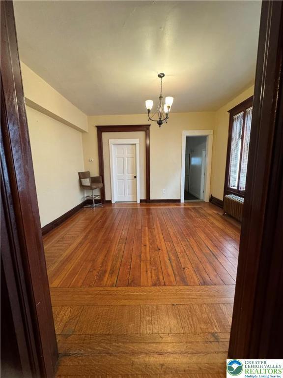 528 N 6th St, Allentown City, PA 18102 - unfurnished dining area with radiator, a chandelier, baseboards, and wood-type flooring
