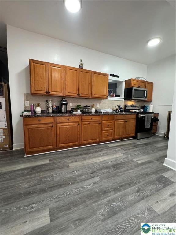 528 N 6th St, Allentown City, PA 18102 - kitchen featuring stainless steel appliances, brown cabinetry, dark wood-type flooring, decorative backsplash, and baseboards
