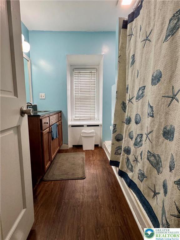 528 N 6th St, Allentown City, PA 18102 - bathroom featuring wood finished floors, a shower with curtain, vanity, and baseboards