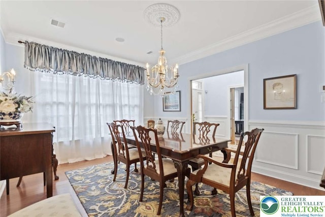 4741 Pinehurst Cir, Upper Saucon Twp, PA 18034 - dining area with a chandelier, wood finished floors, a wainscoted wall, and crown molding