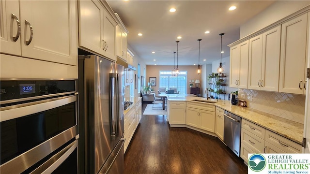 4082 Rutz Ln, South Whitehall Twp, PA 18104 - kitchen featuring appliances with stainless steel finishes, a sink, a peninsula, open floor plan, and dark wood-style floors