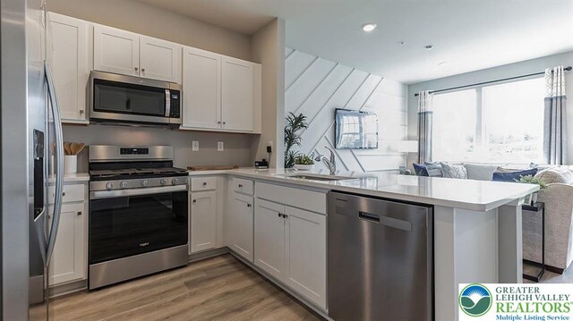 1225 Susan Cir, Upper Macungie Twp, PA 18031 - kitchen with stainless steel appliances, a sink, open floor plan, a peninsula, and light countertops