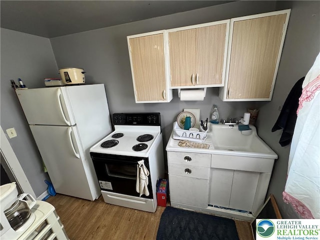 321 W Broad St, Tamaqua Borough, PA 18252 - kitchen featuring electric range oven, freestanding refrigerator, light wood-style floors, light countertops, and light brown cabinets