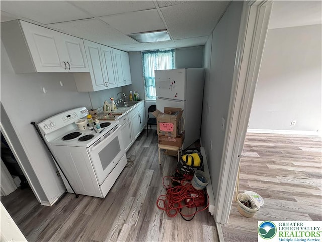321 W Broad St, Tamaqua Borough, PA 18252 - kitchen with white appliances, wood finished floors, a sink, light countertops, and white cabinetry