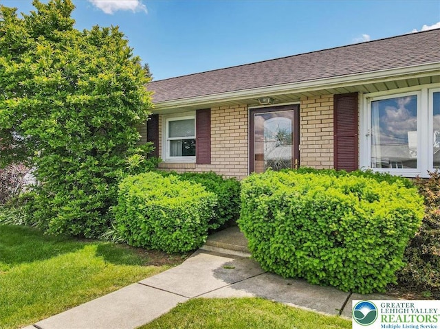 2934 Keystone St, Bethlehem Twp, PA 18020 - entrance to property featuring brick siding, a shingled roof, and a yard