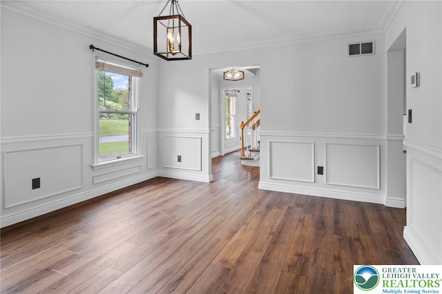 5753 Shady Ln, Plainfield Twp, PA 18064 - unfurnished dining area featuring a chandelier, dark wood-style floors, a wainscoted wall, crown molding, and stairs
