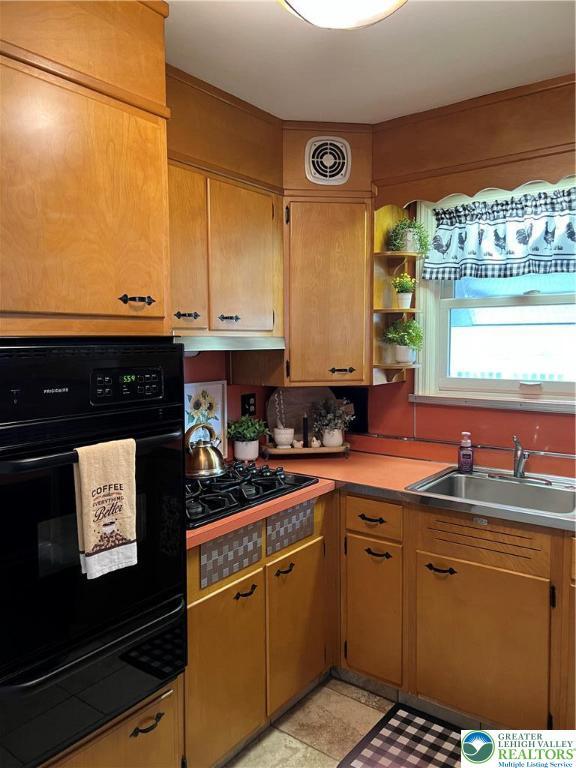 1540 Riegel St, Hellertown Borough, PA 18055 - kitchen featuring a warming drawer, a sink, black appliances, light countertops, and decorative backsplash