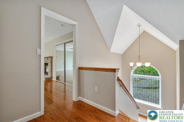 2330 Burntwood Dr, East Stroudsburg, PA 18301 - corridor with a chandelier, an upstairs landing, wood finished floors, and vaulted ceiling