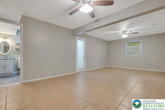 2330 Burntwood Dr, East Stroudsburg, PA 18301 - spare room featuring light tile patterned floors, ceiling fan, a textured ceiling, and beamed ceiling