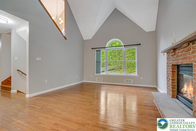 2330 Burntwood Dr, East Stroudsburg, PA 18301 - unfurnished living room with a fireplace, light wood-type flooring, and high vaulted ceiling