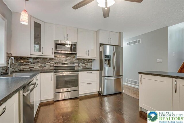 2330 Burntwood Dr, East Stroudsburg, PA 18301 - kitchen with stainless steel appliances, a ceiling fan, dark wood-type flooring, tasteful backsplash, and dark countertops