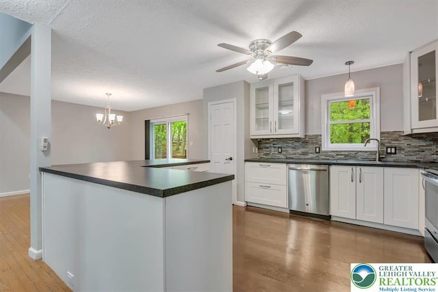 2330 Burntwood Dr, East Stroudsburg, PA 18301 - kitchen with appliances with stainless steel finishes, dark countertops, wood finished floors, backsplash, and a textured ceiling