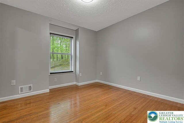 2330 Burntwood Dr, East Stroudsburg, PA 18301 - empty room with light wood-style flooring and a textured ceiling