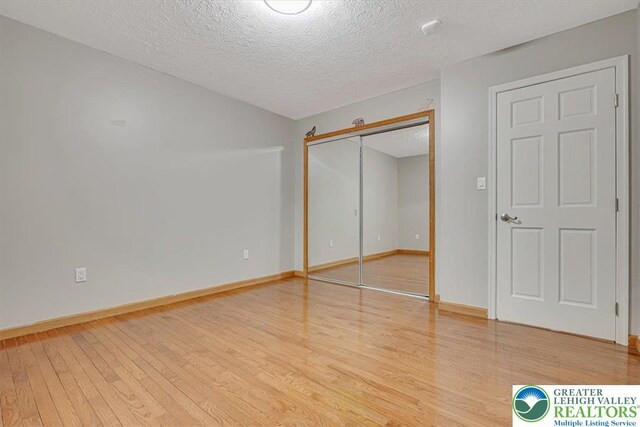 2330 Burntwood Dr, East Stroudsburg, PA 18301 - unfurnished bedroom with light wood-type flooring, a textured ceiling, and a closet