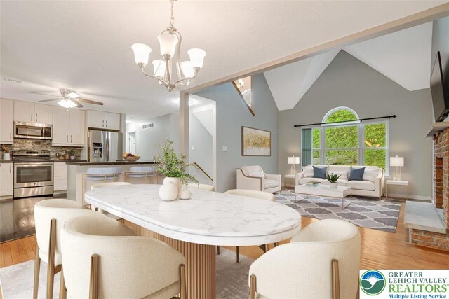 2330 Burntwood Dr, East Stroudsburg, PA 18301 - dining room with light wood-type flooring, a ceiling fan, a chandelier, and high vaulted ceiling