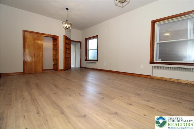 1171 E 4th St, Bethlehem City, PA 18015 - empty room with radiator heating unit, wood finished floors, a chandelier, and baseboards