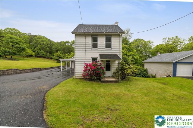 735 Beaver Run Dr, Mahoning Township, PA 18235 - view of front of house featuring a chimney, a front yard, a detached garage, and asphalt driveway