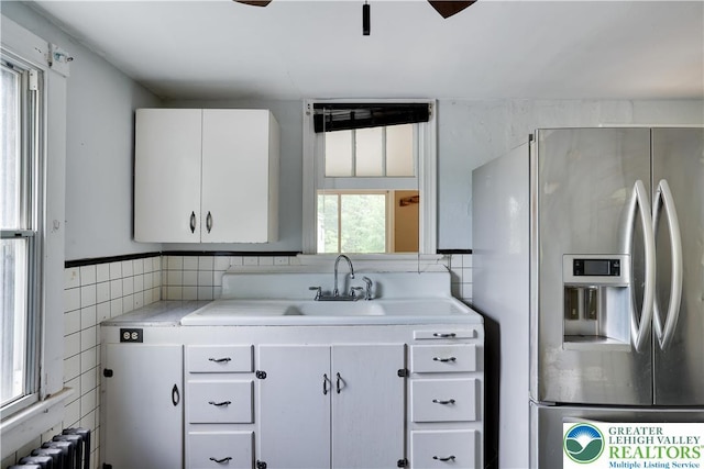735 Beaver Run Dr, Mahoning Township, PA 18235 - kitchen with stainless steel fridge with ice dispenser, radiator heating unit, light countertops, white cabinetry, and tile walls