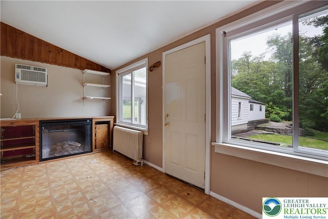 735 Beaver Run Dr, Mahoning Township, PA 18235 - kitchen featuring radiator heating unit, an AC wall unit, vaulted ceiling, a glass covered fireplace, and baseboards