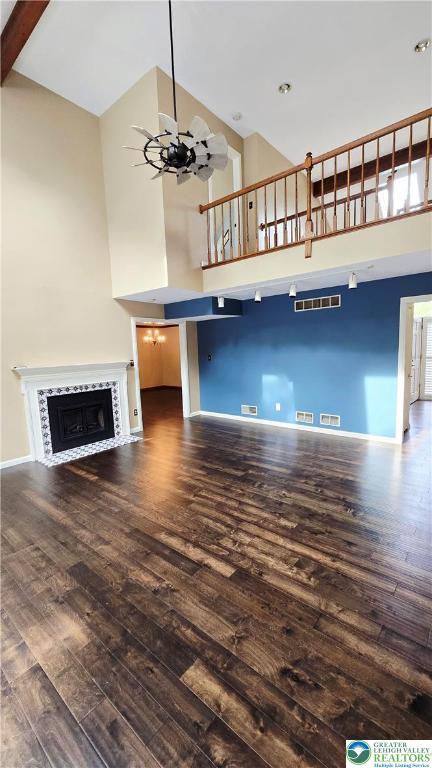 2872 Sheffield Dr, Lower Macungie Twp, PA 18049 - unfurnished living room with a high ceiling, hardwood / wood-style flooring, baseboards, a fireplace with flush hearth, and a chandelier