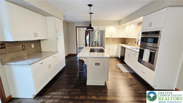 2872 Sheffield Dr, Lower Macungie Twp, PA 18049 - kitchen with stainless steel appliances, a kitchen island, white cabinetry, tasteful backsplash, and a breakfast bar area