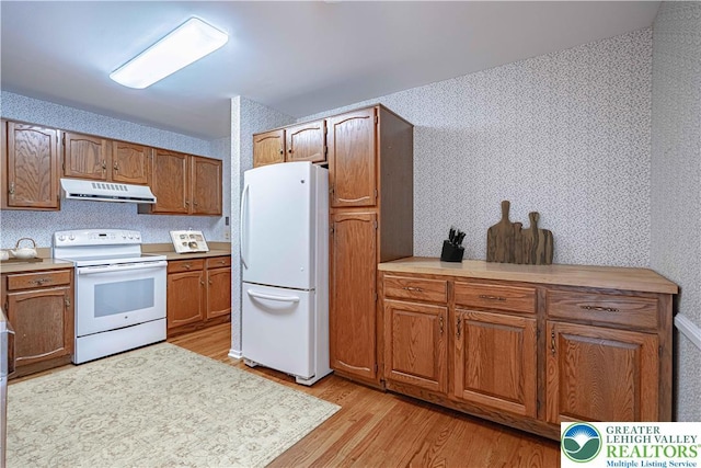 603 Main St Unit 10, Bethlehem City, PA 18018 - kitchen with white appliances, range hood, light wood-type flooring, brown cabinetry, and light countertops