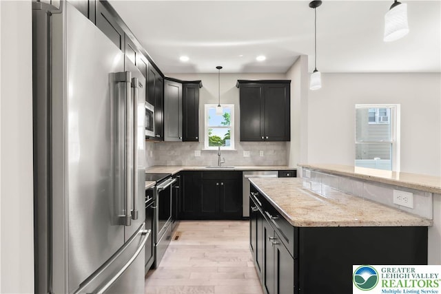 721 7th St, Whitehall Twp, PA 18052 - kitchen with appliances with stainless steel finishes, light wood-style floors, dark cabinetry, backsplash, and a sink
