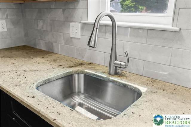 721 7th St, Whitehall Twp, PA 18052 - kitchen view of a sink, tasteful backsplash, and light stone counters