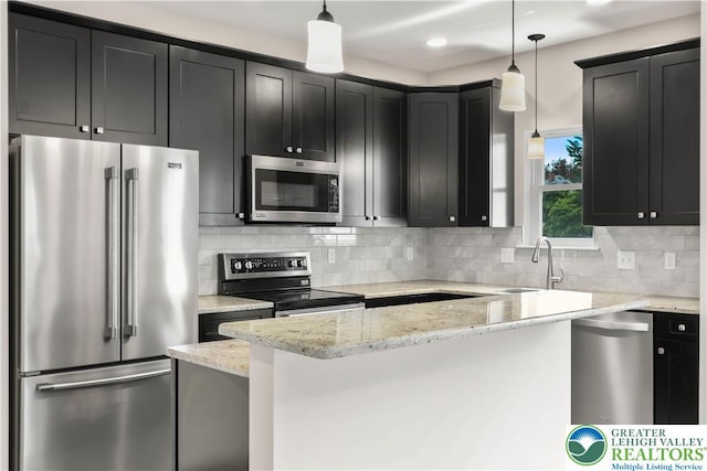 721 7th St, Whitehall Twp, PA 18052 - kitchen featuring stainless steel appliances, a sink, dark cabinetry, light stone countertops, and decorative backsplash