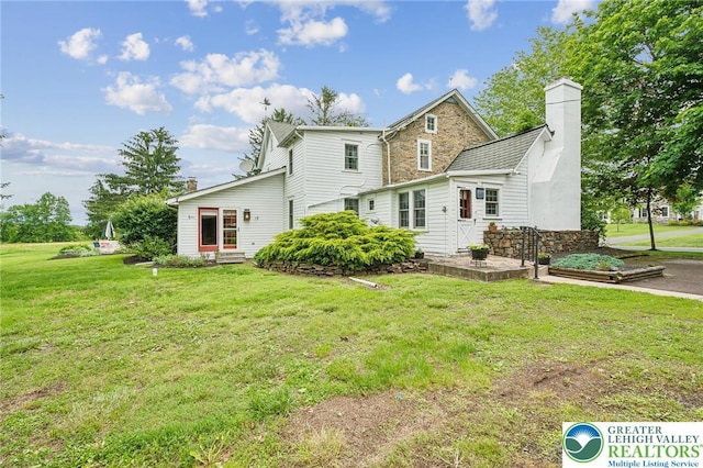 1132 Upperstump Rd, Hilltown Twp, PA 18914 - rear view of house featuring a chimney, a yard, stone siding, and entry steps