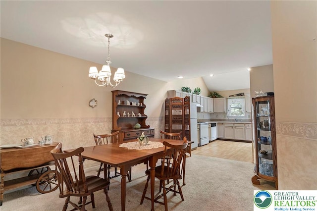 8077 Cross Creek Cir, Upper Macungie Twp, PA 18031 - dining space with vaulted ceiling, a chandelier, light carpet, and a wainscoted wall