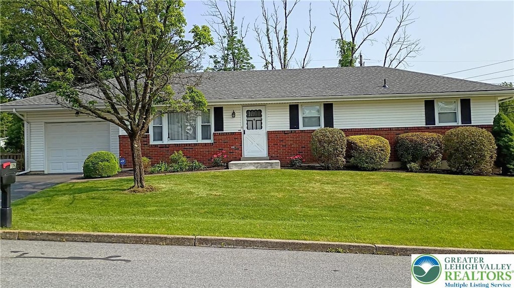 106 3rd Ave, Walnutport Borough, PA 18088 - ranch-style house with brick siding, an attached garage, a front lawn, and asphalt driveway